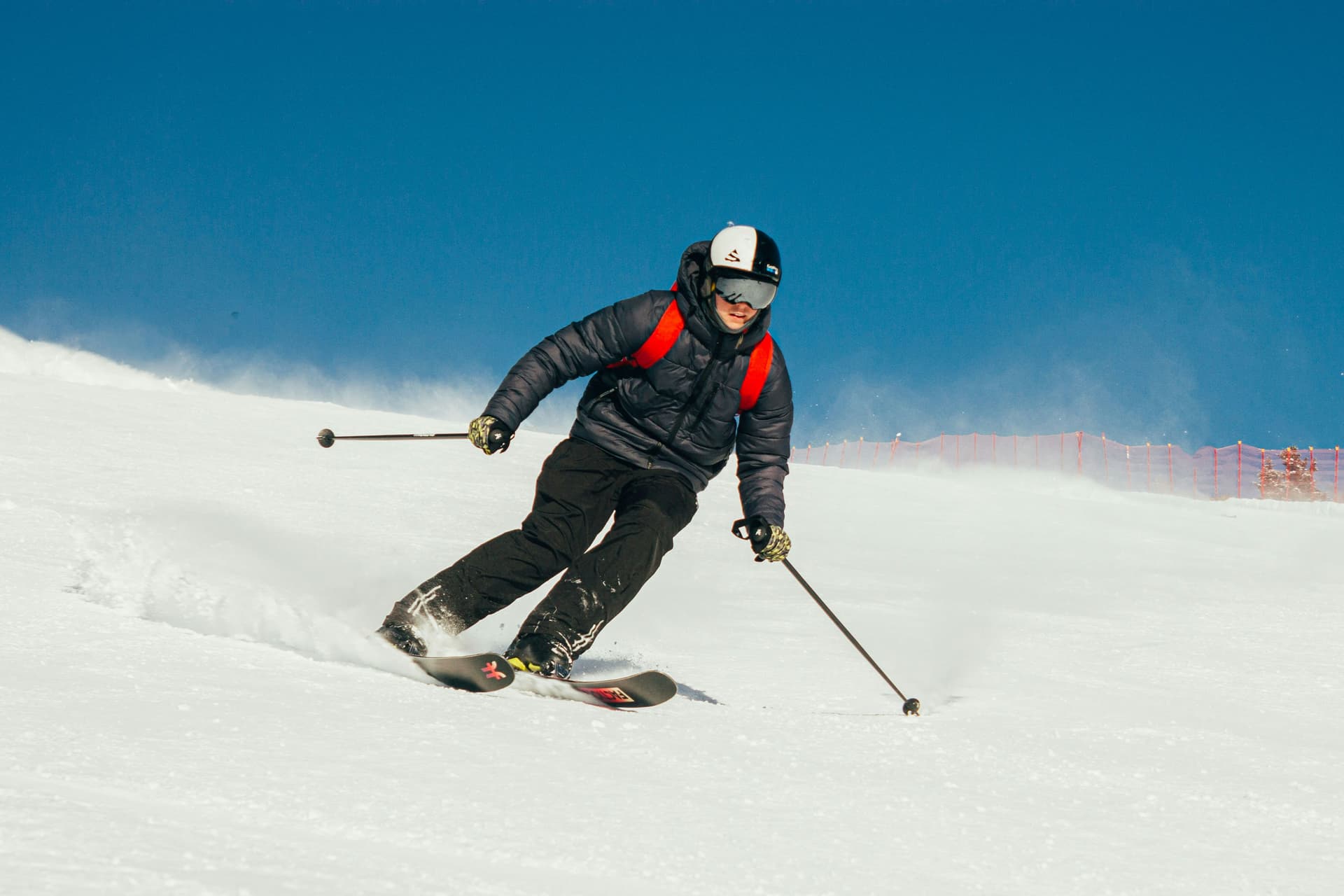 Man-skiing-with-ski-poles-down-slope
